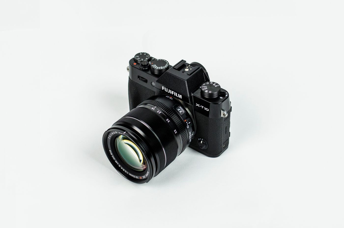 A mirrorless camera with its lens on a light tabletop