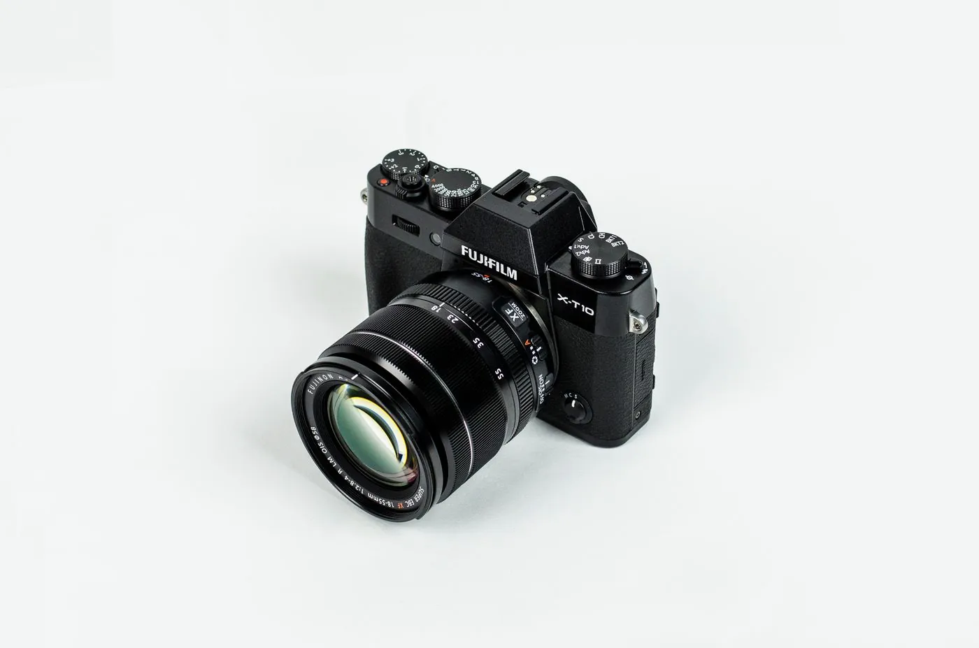 A mirrorless camera with its lens on a light tabletop