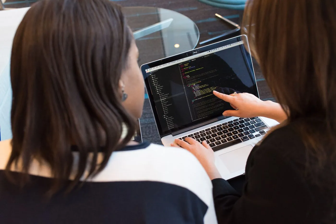 Two people reviewing a project on a laptop