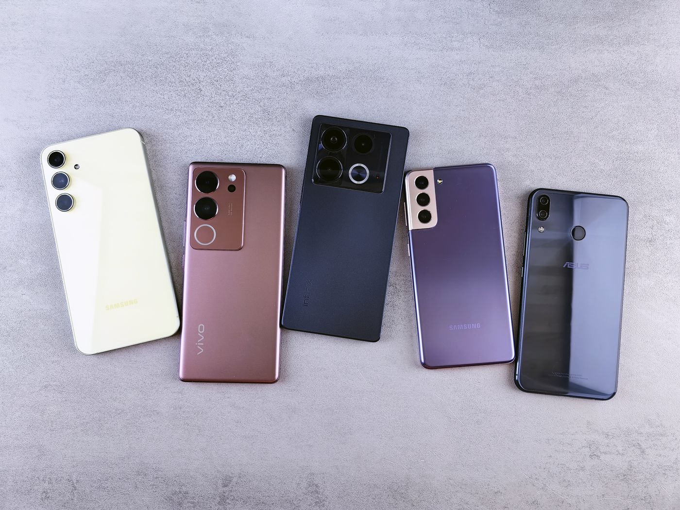 Five smartphones arranged on a gray surface